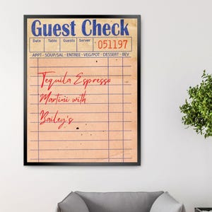 May include: A vintage-style guest check with a black frame. The check has a red and blue header that reads "Guest Check". The check is filled out with the text "Tequila Espresso Martini with Bailey's".