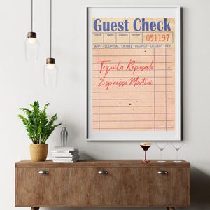 May include: A vintage-style guest check with the text "Guest Check" printed in blue at the top. The check has a light pink background with blue lines and the text "Tequila Reposado" and "Espresso Martini" written in red.