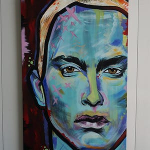 May include: A colourful abstract portrait painting of a person with blue, green, yellow, and pink paint. The person's face is the main focus of the painting.