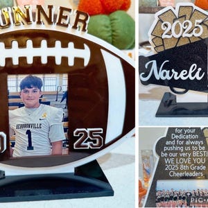May include: Custom photo frames with a football and cheerleader theme. One frame features a football shape with the name "GUNNER" and the years "20" and "25". Another frame is shaped like a megaphone with the name "Nareli" and the year "2025". A third frame has a photo of a cheerleading team and the text "WE LOVE YOU 2025 8th Grade Cheerleaders".