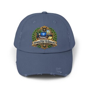 May include: A blue distressed baseball cap featuring a central graphic emblem with a laptop, router, and phone. The text reads DIRECTOR OF INFORMATION TECHNOLOGY FAMILY DIVISION, surrounded by a green laurel wreath and a compass icon at the top.