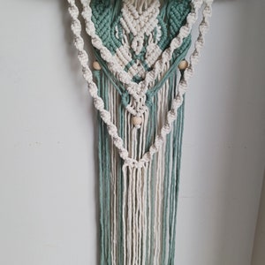 Macramé wall hanging with drift wood and light bead accents.