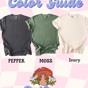 May include: Color guide for a t-shirt in three colors: pepper, moss, and ivory. The t-shirt has a vintage look and is displayed on a pink and white checkered background. The text "Color Guide" is written in a blue, cursive font. Below the t-shirts, the text "Drifting" is written in a blue, cursive font with a mushroom illustration.