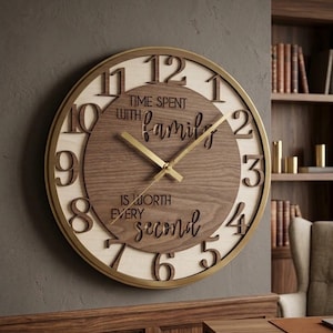 May include: A round wall clock with a gold-toned frame, featuring a light wood outer ring with dark brown raised numerals from 1 to 12. The center is a dark wood circle with the text "TIME SPENT WITH family IS WORTH EVERY second" and gold hands.