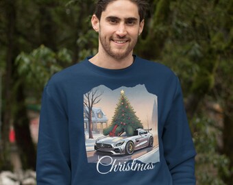 May include: A navy blue sweatshirt with a Christmas-themed design featuring a silver car with a Christmas tree on top. The design is surrounded by a white, torn paper frame. The text "Christmas" is printed below the design.