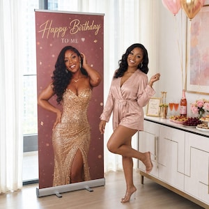 May include: A tall, rectangular retractable banner featuring a dark maroon background with gold confetti accents and the text Happy Birthday TO ME. The banner displays a life-sized photograph of a person wearing a gold sequined strapless gown.