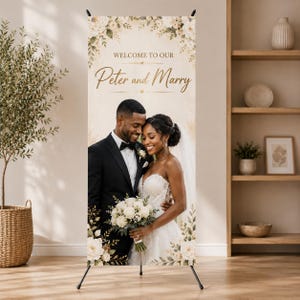 May include: A vertical wedding welcome banner on a black tripod stand featuring a photograph of a couple. The text reads WELCOME TO OUR Peter and Marry. The design includes cream-colored floral illustrations at the top and bottom corners.