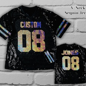 May include: Black sequin jersey with a V-neck design. The jersey features the word "CUSTOM" above the number "08" in a holographic font. The sleeves have holographic stripes. A smaller jersey with "JONES" and "08" is also shown.