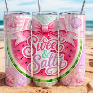 May include: A cylindrical tumbler with a metal straw featuring a pink watermelon slice graphic, a large pink bow, and seashells. The text Sweet & Salty is printed in a decorative script font. The background includes a pink and white checkered pattern.