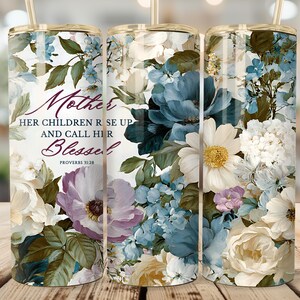 May include: Three stainless steel tumblers with floral designs and gold-coloured lids and straws. The tumblers feature a watercolour design of white, blue, and purple flowers with the text "Mother, Her Children Rise Up and Call Her Blessed, Proverbs 31:28."