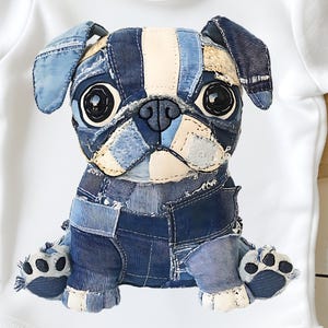 Könnte beinhalten: Ein weißer Baby-Body mit einem Patchwork-Mops-Design. Der Mops ist aus verschiedenen Denim-Farben gefertigt, mit schwarzen Augen und einer schwarzen Nase. Die Ohren und ein Streifen auf dem Kopf sind hellbeige. Die Pfoten sind hellblau mit schwarzen Pfotenabdrücken.
