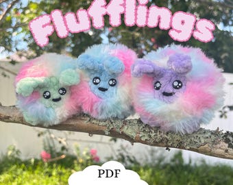 May include: Three fluffy, colorful, crocheted plushies with embroidered eyes and mouths. The plushies are sitting on a branch. The plushies are pink, blue, and green. The text "Flufflings" is written in a pink cloud above the plushies. The text "PDF Pattern" is written in a white cloud below the plushies.
