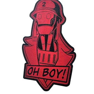 May include: A red and black graphic featuring a helmeted figure with the text "OH BOY!". The figure wears a respirator and a military-style helmet with the number "2". The design is a stylized illustration, suitable for a badge or sticker.