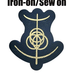 Op de afbeelding: Een marineblauwe opstrijkbare patch met een goudkleurig geometrisch ontwerp. De patch heeft een unieke vorm en de tekst "Iron-on/Sew on" in zwarte letters staat bovenaan.