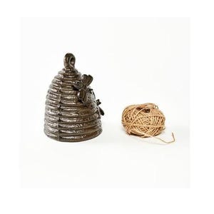 May include: A bronze-coloured beehive-shaped container with a bee accent, next to a ball of twine. The beehive has a textured surface and a loop at the top. The twine is a natural tan colour.