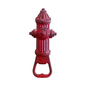 May include: A red cast iron bottle opener in the shape of a fire hydrant. The opener has a distressed finish, with rust-like details. The design includes the hydrant's cap, nozzles, and a bottle-opening slot at the base.