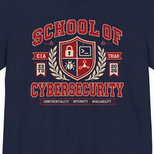 Op de afbeelding: Een marineblauw t-shirt met korte mouwen en een rood-witte opdruk met de tekst School of Cybersecurity. Het ontwerp bevat een schild met iconen van een slot, een opdrachtprompt, een kever en een molecuul, omringd door laurierbladeren en tekst.