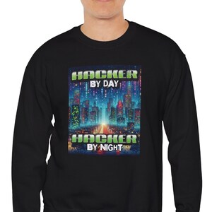 May include: A black sweatshirt with a graphic print of a cityscape and the text "Hacker by Day Hacker by Night".