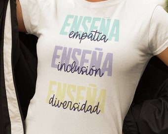 May include: White t-shirt with the text "ENSEÑA empatía, ENSEÑA inclusión, ENSEÑA diversidad" in colourful lettering.