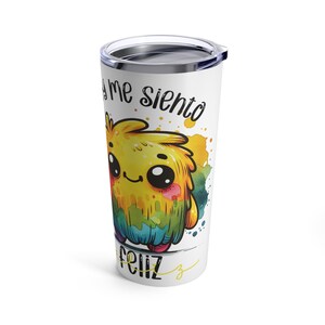 May include: A white stainless steel tumbler with a colorful cartoon monster and the text "Hoy me siento feliz" in black.