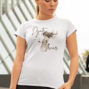 May include: White t-shirt with a drawing of a woman with long hair blowing in the wind. The text "Déjate llevar" is printed on the shirt.