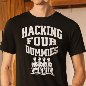 Puede incluir: Camiseta negra con texto blanco que dice "Hacking Four Dummies" y un gráfico de cuatro figuras de palo sentadas en un banco.
