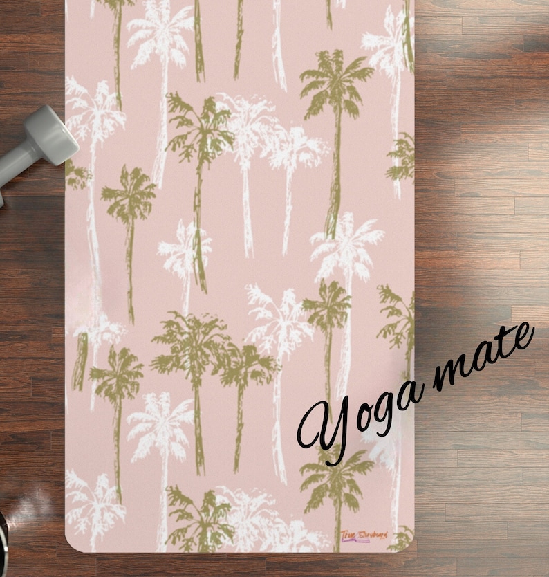 May include: A pink yoga mat with a palm tree pattern. The text "Yoga mate" is written in black cursive on the mat.
