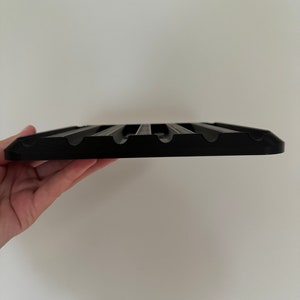 May include: Black plastic tray with multiple slots for holding items, such as utensils or tools.