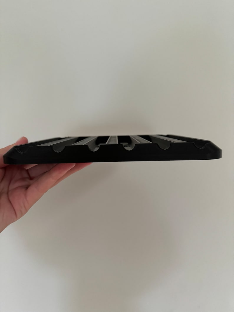 May include: Black plastic tray with multiple slots for holding items, such as utensils or tools.
