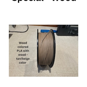 May include: A spool of wood-colored PLA filament for 3D printing. The filament is a tan/beige color.