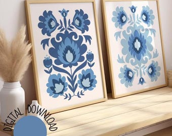 May include: Two framed prints with a blue and white floral pattern. The prints are hung on a light wood wall.