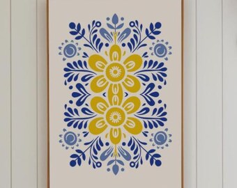 May include: A framed art print featuring a symmetrical floral design. The artwork showcases two large yellow flowers at the center, surrounded by blue and yellow leaf and petal motifs. The print is set against a cream background and framed in a brown wooden frame.