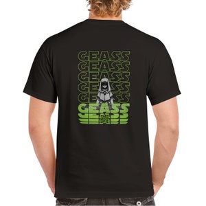 Op de afbeelding: Zwart T-shirt met een grafisch ontwerp op de achterkant. Het ontwerp bevat het woord "GEASS" in groen en een gestileerd anime-personage. Het shirt is gemaakt van een zacht, comfortabel materiaal.
