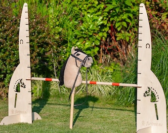 May include: A wooden horse jumping obstacle course with a white and red bar, two wooden height markers, and a brown stuffed horse head with a black bridle.