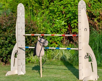May include: A wooden horse jumping obstacle course with two wooden poles and a brown and white stuffed horse head with a black bridle.