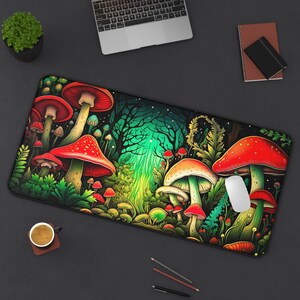 Puede incluir: Una alfombrilla de escritorio rectangular con una vibrante ilustración de un bosque de hongos caprichoso. El diseño presenta grandes hongos de sombrero rojo con puntos blancos, sobre un fondo de exuberante follaje verde y un bosque místico y brillante.