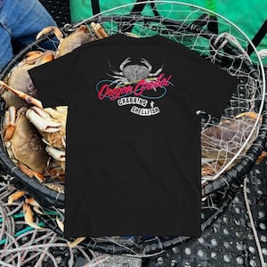 May include: Black t-shirt with a graphic of a crab and the text "Oregon Coastal Crabbing & Shellfish".