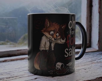 May include: A black ceramic mug featuring a cartoon fox wearing a white shirt and tie, looking stressed with a hand on its forehead. A spilled mug labeled COFFEE lies on the ground. The text reads Oh for fox sake in white and red lettering.