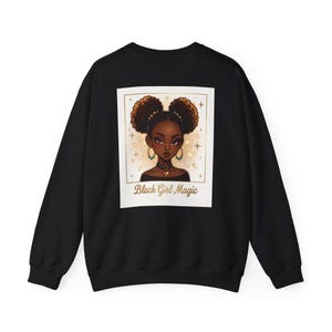 Puede incluir: Una sudadera negra de manga larga con un estampado gráfico rectangular en la espalda. El diseño muestra la ilustración de una persona de piel oscura con dos moños afro, que lleva un collar con colgante de corazón y el texto Black Girl Magic.