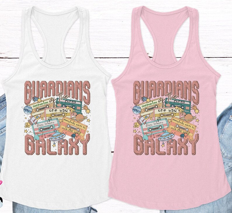 May include: Two white and pink tank tops with a retro design featuring the text "Guardians of the Galaxy" with cassette tapes, planets, and stars.