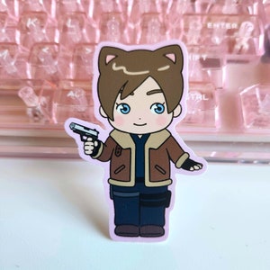 May include: A cartoon sticker of a person with brown hair, wearing a brown jacket, blue jeans, and holding a gun. The person has cat ears and a light pink background.