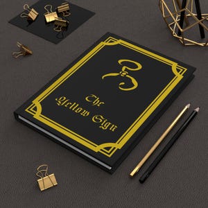 Libro sobrenatural lovecraftiano que representa el signo amarillo del rey en amarillo Misteriosa ficción espeluznante Terror cósmico Cuaderno de tapa dura Mate