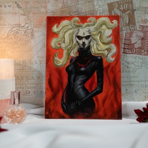 May include: A painting of a woman with long blonde hair, wearing a black leather outfit. She is standing in front of a red background with flames.