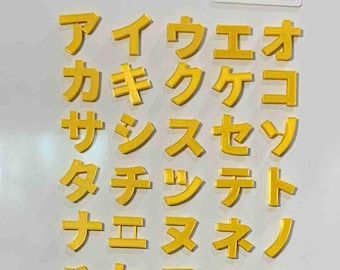 May include: A collection of yellow, three-dimensional Japanese katakana characters arranged in a grid on a white surface. The characters are organised in columns and rows, and the brand name Electrolux is printed in the top right corner.