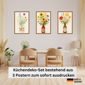 May include: Set of three framed art prints featuring floral arrangements in jars and bottles. One print shows flowers in a Nutella jar, another in a ketchup bottle, and the third in a beer bottle. The prints are displayed on a wall above a dining table.