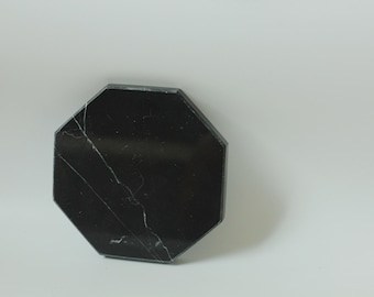 Puede incluir: Posavasos octogonal de mármol negro con vetas blancas.