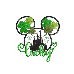 Puede incluir: Un diseño del Día de San Patricio con forma de cabeza de Mickey Mouse con tréboles verdes y una silueta de castillo negro. La palabra "lucky" está escrita en verde. La imagen está disponible en 7,6, 10,2 y 12,7 cm.