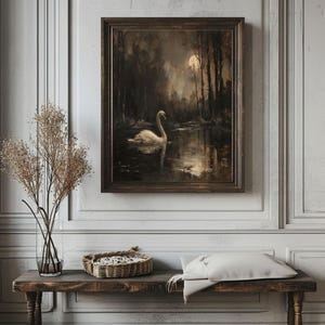 May include: A framed painting of a white swan swimming in a dark, moonlit lake. The swan is in the center of the image, with the moon and trees in the background.