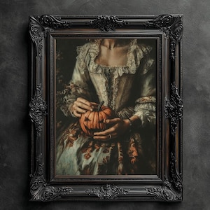 K&ouml;nnte beinhalten: Gerahmtes Gem&auml;lde im Vintage-Stil, das eine Person mit einem geschnitzten K&uuml;rbis zeigt. Die Person tr&auml;gt ein cremefarbenes Kleid mit Spitzendetails. Der verzierte schwarze Rahmen verleiht eine gotische &Auml;sthetik, ideal f&uuml;r Halloween.