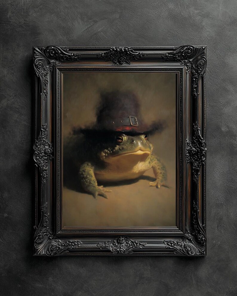May include: A framed portrait of a large toad wearing a dark hat with a buckle. The toad is green and tan, set against a neutral background. The ornate black frame adds a classic touch to the artwork.